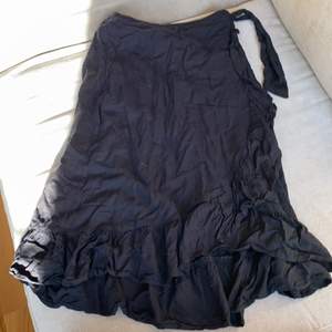 En jättefin svart kjol som man kan knyta upp till midjan. Säljer för att  inte har använt den så mycket. 