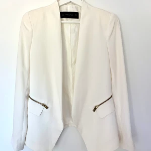 Helt ny blazer från Zara/ oanvänd/ stl M/ vit kavaj - Helt oanvänd vit kavaj från Zara. Nypris 700 kronor. Storlek M, men fungerar även till S då den är lite liten i storleken. Säljes då den tyvärr är för liten för mig! Fickor på sidorna av kavajen. Fint tyg. Kan postas spårbart för 66 kr. 