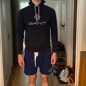 Gant hoodie - En marinblå gant hoodie i otroligt bra skick. Nypris var runt 1200kr och köptes på Hanzens i Umeå för ca 1 år sen. Säljs pågrund av att den tyvärr är förliten. Storlek M:)