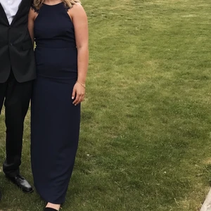 Marinblå balklänning NLY eve 34  - Säljer min fina marinblåa balklänning från 9an. Använd varsamt 1 gång. Hela klänningen är 148 cm lång. Den är insydd vid brösten men går lätt att sprätta upp vid behov. 