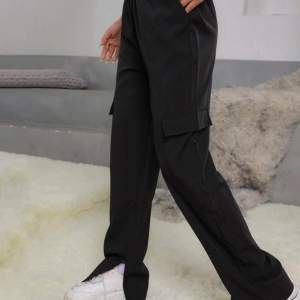 Svarta byxor i storlek s med fickor och slits
