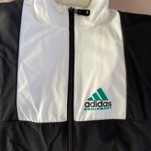 Adidas windbreaker - Windbreaker jacka från Adidas i svartvit samt grön | strl XS passar mig som har M sitter som en S ish | använd fåtal gånger | frakt tillkommer