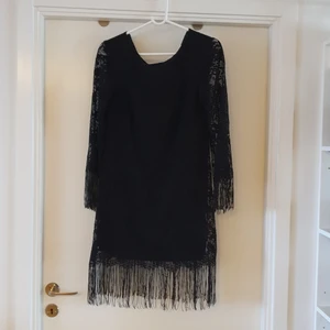 Spetsklänning med fransar - Snygg svart festklänning i spets med fransar. Använd 1 gång.