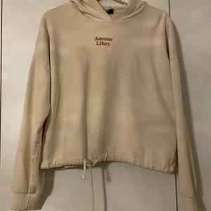Hoodie från Gina Tricot - En beige hoodie med texten amoure libre på bröstet och den har även så att man kan knyta den i midjan. 