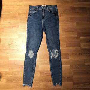 Säljer mina jeans från Gina Tricot då de ej används längre, fint skick! Höga i midjan,slitningar vid knäna och längst ner där byxan slutar. 