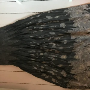 Charmig långkjol  - JÄTTEFIN LÅNGKJOL(kan användas som klänning) ! resår i hela midjan med blomstermönster. Är egentligen utklädningskläder men personligen har använt som en vanlig kjol/klänning. Material polyester! 