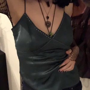 Mörkgrönt linne - Jättecoolt och så snyggt mörkgrönt linne med små detaljer längst upp i form av pärlor. Super bekvämt och utan defekter. Älskar det men bara använt fåtal gånger och därav säljer jag linnet. Passar till många olika stilar! Köpt secondhand :) 