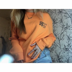 Sweatshirt orange med tryck - Säljer en orange sweatshirt med tryck på fram- och baksida. Tröjan är i strl M herr, sitter pösigt på mig och är använd endast ett fåtal gånger. Meddela mig vid fler frågor!😊