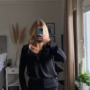 Svart blus med volanger  - Svart blus med volanger från Gina 