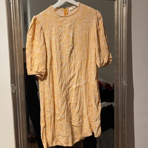 Gul blommig klänning  - Inte struken på bilden, men super söt gul klänning med lite ballong ärmar 