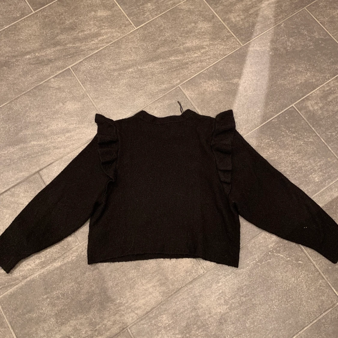 Svart tröja med volang  - 90