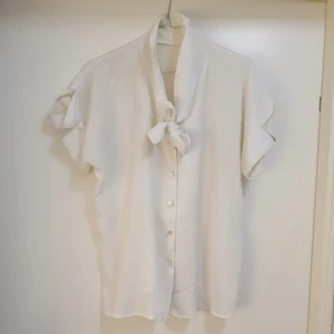 Vit skimrande oversize blus för dam. - Vit oversize-blus för dam inköpt second hand. Oklart vilken storlek men passar mig som är S. 