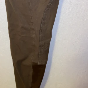 Ridbyxa knäskodd - Nyskick - Knäskodd ridbyxa. Stretch längst ner i slutet av byxan. Hög midja. Endast liten söm som gått upp på ena skoningen!                                                                                   ‼️NYSKICK‼️ Endast använda fåtal gånger, då jag snabbt växte ur dem snabbt!                                                         Priset kan diskuteras. Frakten står köparen för! (Förslaget fraktalternativ nedan.) Även hämtas i Frändefors. 