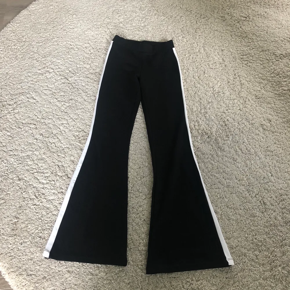 Svarta utsvängda byxor med vita ränder på sidan av benen. Bra skick🤩 köparen står för frakt . Jeans & Byxor.