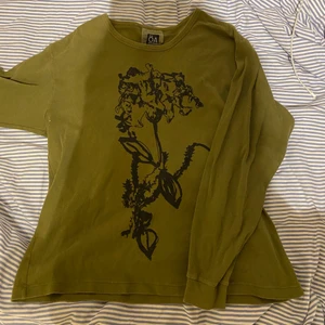 Grön tröja med tryck  - Militärgrön långärmad tröja med tryck från ÖA, använd ca 2 gånger så i fint skick! 