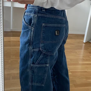 Baggy jeans. - Super snygga baggy jeans med mycket detaljer. Det har blivit lite hål på knät men inget som inte skulle gå att laga eller rocka!har vuxit ifrån denna stil därför säljs det! 