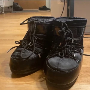 Glansiga svarta moon boots  - Ett par sjukt snygga moon boots som just denna färg är slutsålda på varje sida! Älskar dem men inte riktigt min stil☹️ är i nyskick endast använde fåtal gånger o inga defekter osv💗 skriv privat för fler bilder!💕 köp direkt: 1500kr❌BUDGIVNING: HÖJ MED MINST 10kr❌ OBS: på bilden är snörena konstiga då jag försökt fixa till dem för de va för långa för mig men fixas såklart innan jag säljer dem! 