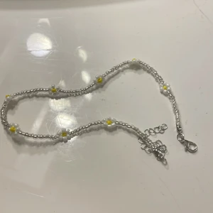 Blommigt halsband  - Ett vitt halsband med små söta vita/gula blommor 