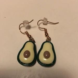 Avokado örhängen  - Avokado berlocker i örhängen man får med klistermärken och en godis och sen ett tack kort 