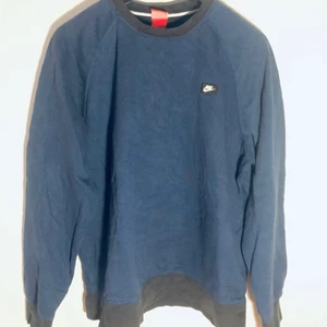 Nike Vintage Tjocktröja Sweatshirt Blå - En riktigt snygg mörkblå och svart tjocktröja från Nike. Storlek XL. Skicket är som på bilderna, har du någon fråga eller vill ha fler bilder är det bara att fråga. Skickas spårbart med postnord, frakt med andra företag kan fixas vid förfrågan.