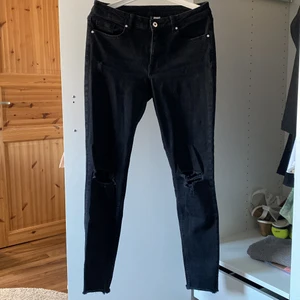 Svarta jeans - Jättefina och sköna svarta jeans med hål på båda knäna. Använda men i väldigt gått skick. De har en ”sliten” stil med ”slitna” cuffs (bild 3). De är i storlek 38 