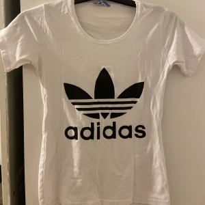 Vit/svart adidas tshirt  - Säljer en vit adidas med svart tryck. Bra skick. I storlek S men kan också passa en XS😍✨