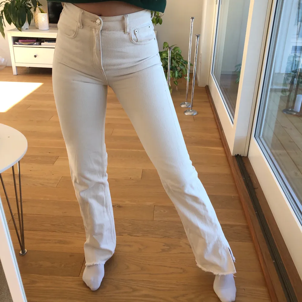 Beiga/vita raka jeans med slits från pull & bear. Storlek 36 men skulle säga att de passar 34 också. Jag är 172 cm lång. . Jeans & Byxor.