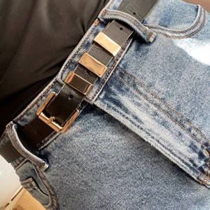 Svart skärp med gulddetaljer - Svart skärp med gulddetaljer. Längden är 100cm. Använt skick vilket man ser kring hålen, men inget som syns när skärpet sitter på 🌿 Köparen betalar frakten!