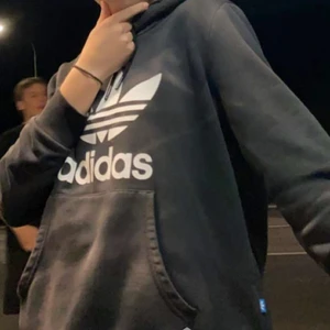 Adidas hoodie - Fin adidas hoodie i storlek M, på mig som brukar ha S är den lite oversized🥰 som du kan se har den bleka fläckar då dem blivit utelämnad i solen en hel vecka på sommaren men det gav en cool efekt tycker jag personligen. Skriv för fler frågor🥰