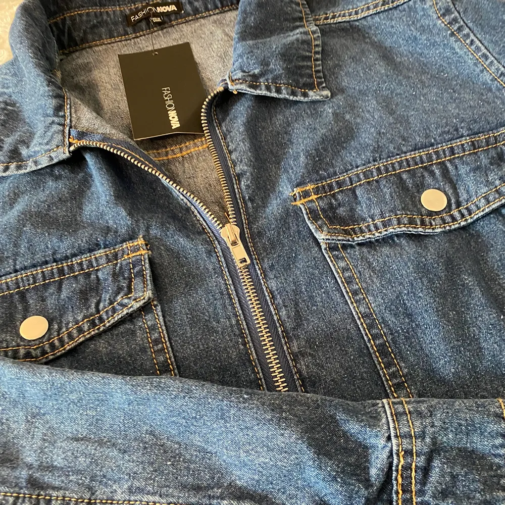 Jeans jumpsuit med fickor och dragkedja och midjebälte. Aldrig använd, prislappen sitter t.o.m kvar. Den är i mycket bra skick och har en snygg passform! (Obs - kunden står för frakten) . Jeans & Byxor.