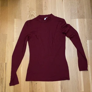 En till fin vinröd tröja, storlek XS - En långärmad vinröd tröja, med tajt krage. Den är tajt vid kroppen och är jättefin. Använd 1/2 gånger för ca 2/3 år sen.
