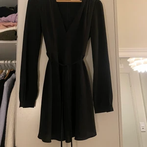 Svart klänning med knytning  - Fin passform, man kan knyta fint runt midjan 