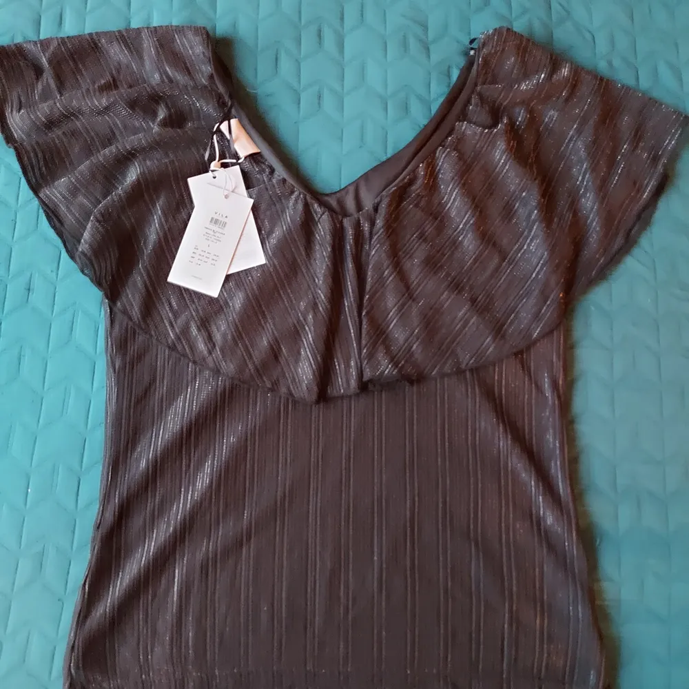 Brand new blouse. Never worn, with price tags in place. Clean, no defects.  Coal black fabric with subtle dark shiny thread (in the pictures, under artificial lighting, it looks faded, but it is not). Beautiful Spanish neckline. Double layered.  Fabric: polyamide, polyester, elastan blend (see tags).  Size: L (40/42)  . Blusar.