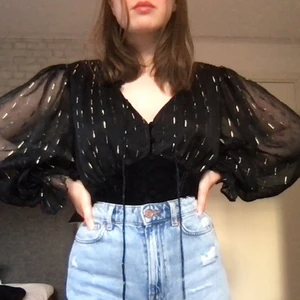 River Island corset blus svart - Jättefin svart blus med gulddetaljer och korsett i velvet-tyg. 🖤 Köpt från Zalando, aldrig använd :) Ursprungligt pris: 849 kr. Frakt kan variera beroende på avstånd. :) perfekt att ha till jul/nyår/fest <3