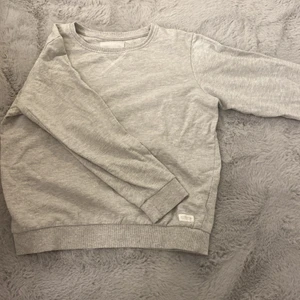 Lager 157, stl 160 - En ljusgrå basic tjocktröja med en detalj vid halsen. Köpt på lager157. Fint skick