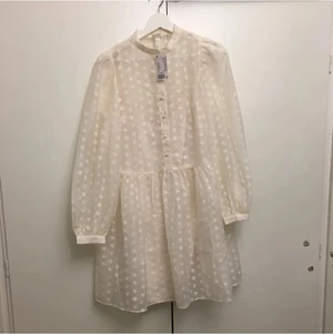 Prickig vit klänning storlek XS-M - Helt ny vit klänning från H&M med prislappen på. Det finns en extra ljusrosa underklänning som sitter fast med den prickiga klänningen. Storlek XS men är stor så passar också S, M. Originalpris 299 kr. Frakt ingår ej 