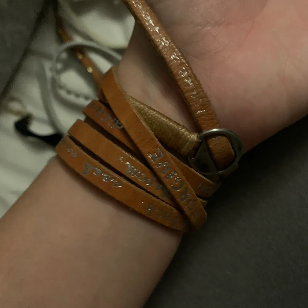 brunt läder armband med silver text. Accessoarer.