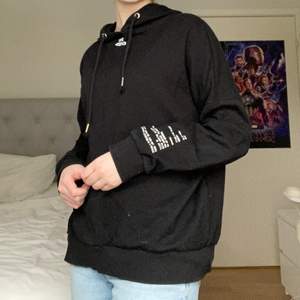 Svart oversized hoodie från H&M divided men olika text motiv runt om på tröjan. Använd men i bra skick