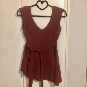 Chiara Forthi Milano - Storlek S. Vinröd. Oanvänd endast provad Fint band runt midjan.  Jag tycker den framhäver former såå fint!  Tyget svallar neråt midjan får den att se smalare ut med höfterna bredare samtidigt som jag upplever att den formarr och trycker upp bröst.