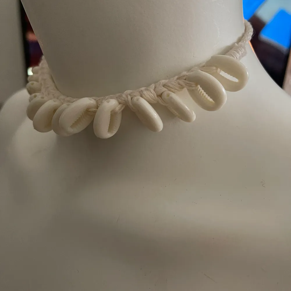 Oanvänt halsband med ”snäckor” på, knyte bak. Accessoarer.