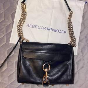 Svart väska med guldiga detaljer från Rebecca minkoff! Går att justera/ ta av kedjan så man kan använda den på olika sätt. Använd en hel del men är fortfrande fin! 