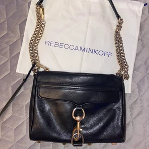 Rebecca Minkoff väska - Svart väska med guldiga detaljer från Rebecca minkoff! Går att justera/ ta av kedjan så man kan använda den på olika sätt. Använd en hel del men är fortfrande fin! 