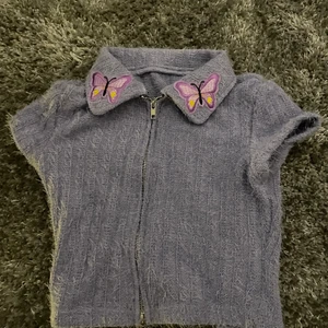 Lila topp - Söt lila topp med en fjäril på kragen. Den har en dragkedja på framsidan. Säljer då den är för liten för mig. 