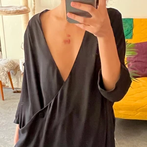 Svart maxiklänning - Pösig och sval med stor ringning, liknar en omlottklänning men den går inte runt. 