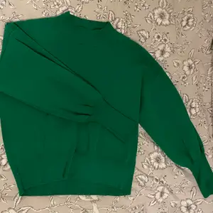 En grön stickad tröja med en lite högre krage upptill och smalare längst ut på armen, tröjan har några år på nacken men har nästan aldrig använts. Den är i storlek M och kommer från Lindex! ❄️