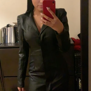 Långärmad klänning i fake skinn - Från NA-KD, storlek XS. Jag är 160 och den går till knäna.