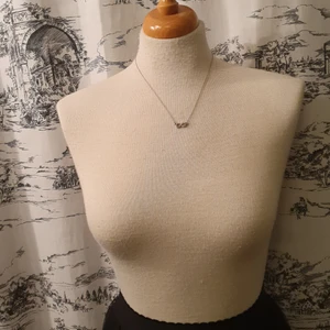 Halsband med symbol - Kort, enkelt och silverfärgat halsband med symbol