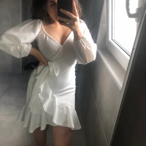 Nelly, vit klänning stl 32 - En vit klänning från Nelly, frill dress, mycket bra skick och har bara använts 1 gång. Klänningen är stretchig. Passar bra till fester och student.