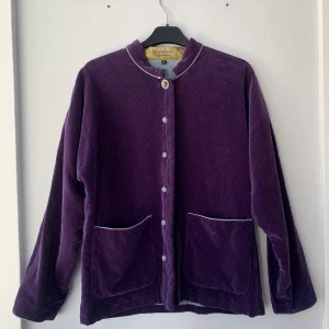 Gudrun Sjödén Jacka - Otroligt fin jacka från Gudrun Sjödén värd över 1000kr 💜 I toppskick och bra kvalitet. Tyget är i lila sammet utanpå och gråblått linne inuti. Stängs med ”knappar” i tyg. Jackan känns tung och varm nog för vår, höst och sommarkvällar 🌸 jag är 157 och den slutar precis under rumpan. 