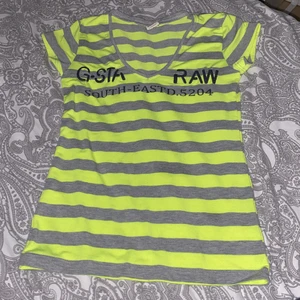 G-staraw t shirt - En t shirt i randig neon gul och grå, sitter ganska tajt och v ringad, köparen står för frakten